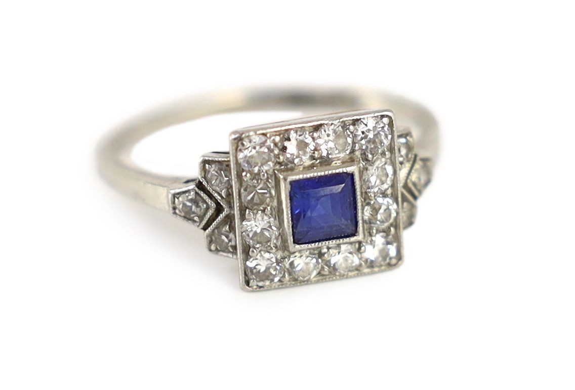 A 1920's/1930's platinum and millegrain set sapphire and diamond tablet cluster ring, with diamond set shoulders